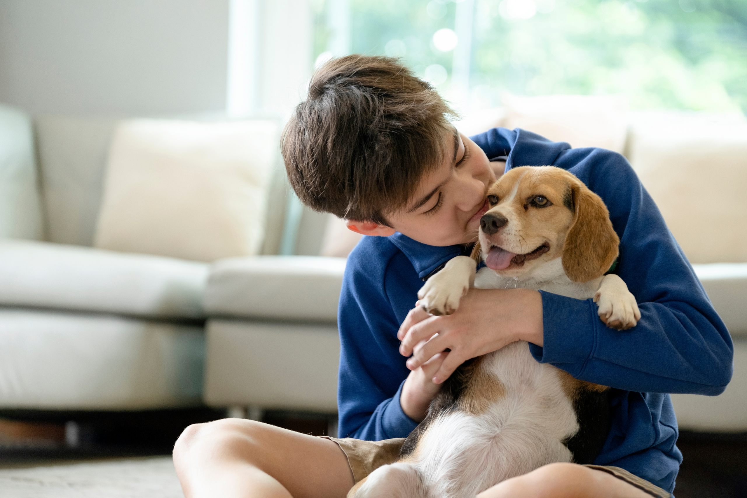 Menino abraçando e beijando um cachorro